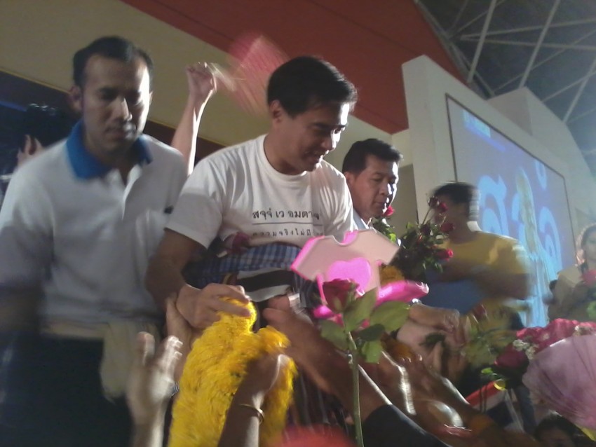 Democratic party supporters shower the former prime minister with flowers and scarves