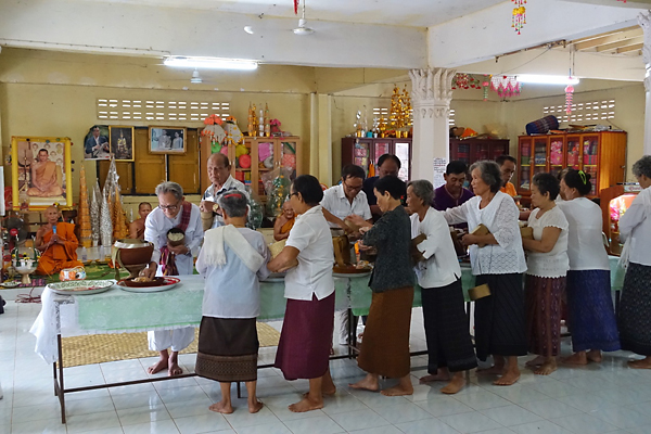 Nabua villagers give alms in the local temple to mark the occasion of the 50th anniversary of the "Day the First Gunshot Rang Out".